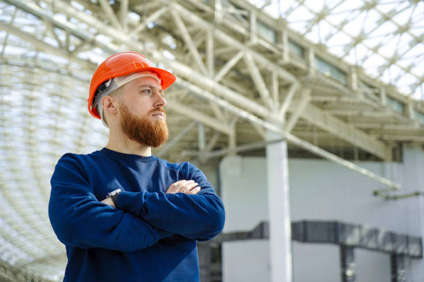 A man in a helmet in a large space crossed his arms stock photo