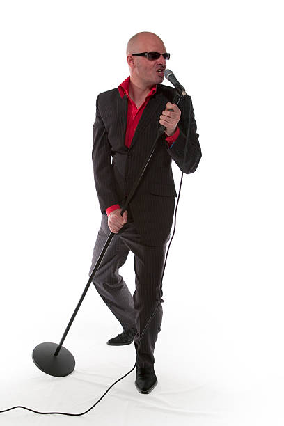 A man in a suit and a red shirt singing on the Karaoke stock photo