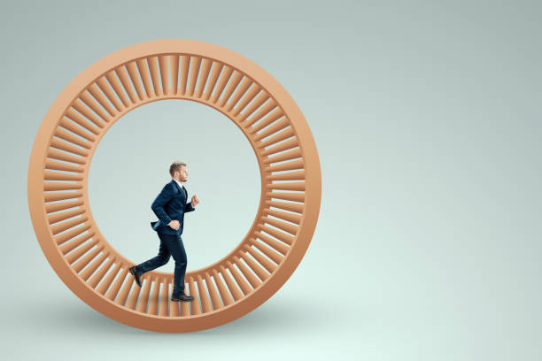 A man in a suit runs in a hamster wheel. The concept of liberation from slavery, life, business, manipulation, control. stock photo