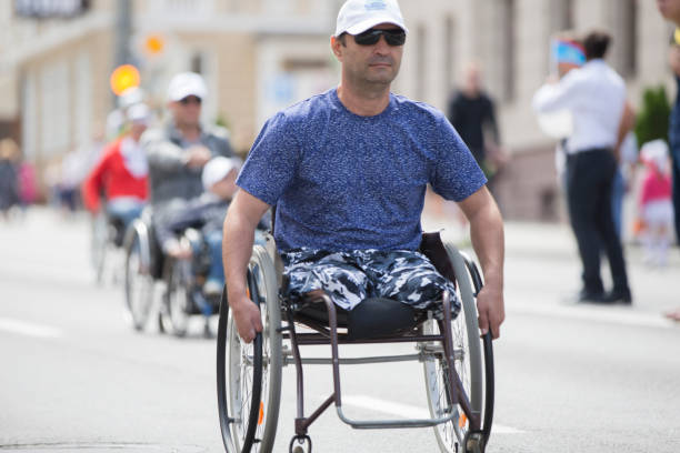 街の路上で車椅子の男 - パラリンピック ストックフォトと画像