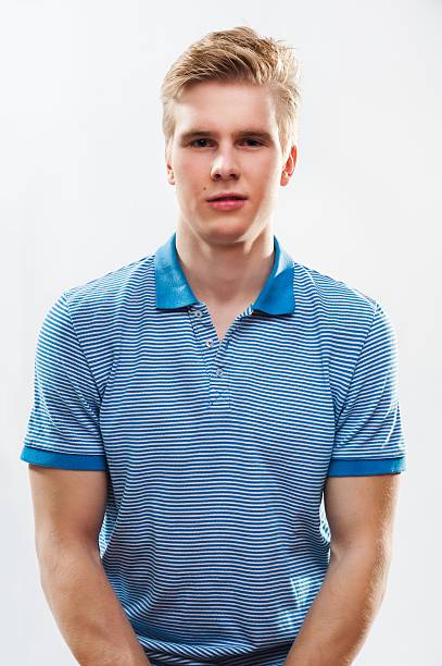 man in blue shirt Portrait of young handsome blond man wearing shirt against grey background teenage boys men blond hair muscular build stock pictures, royalty-free photos & images