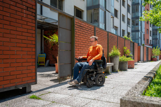 Man in Motorized Wheelchair Returning Home stock photo