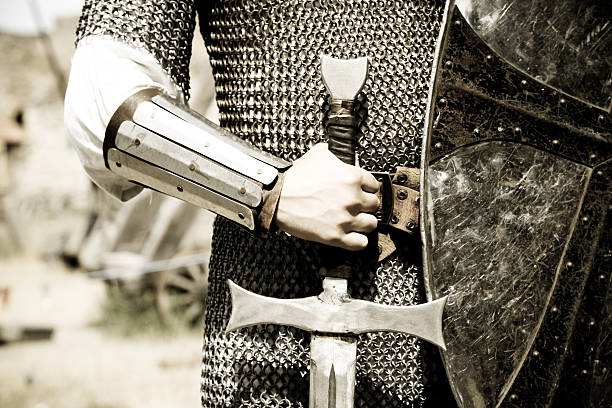 Man in suit of armor with medieval sword stock photo