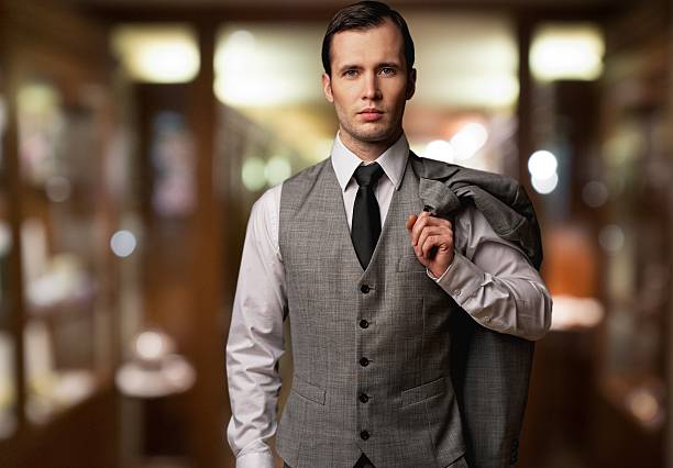 Man in waistcoat with jacket over his shoulder stock photo