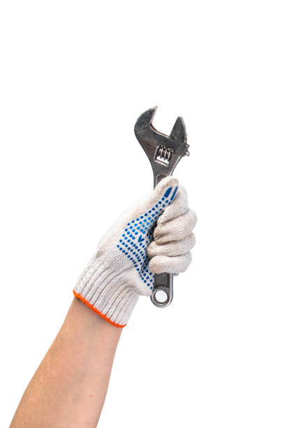 Man in white work gloves holds wrench. Happy labor day. Hand repair tool isolated on white background. stock photo