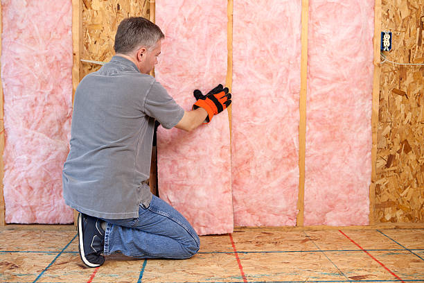 Man Installing Insulation Man installing fiberglass insulation in the wall.Please also see: fibreglass stock pictures, royalty-free photos & images