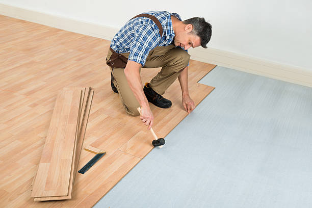 Man Installing New Laminated Wooden Floor Carpenter Installing New Laminated Wooden Floor At Home wood laminate flooring stock pictures, royalty-free photos & images