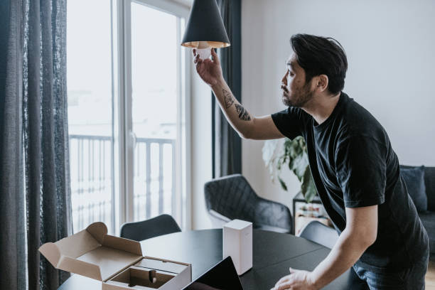 Man installing smart lightbulb stock photo