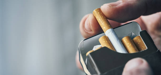 Man is holding black cigarette pack in hand stock photo