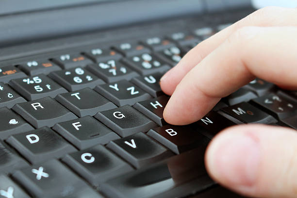 Man is writing with keyboard of laptop stock photo
