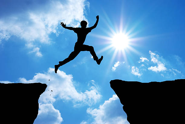 Man jump Man jump through the gap. Conceptual design.  cliff jumping stock pictures, royalty-free photos & images