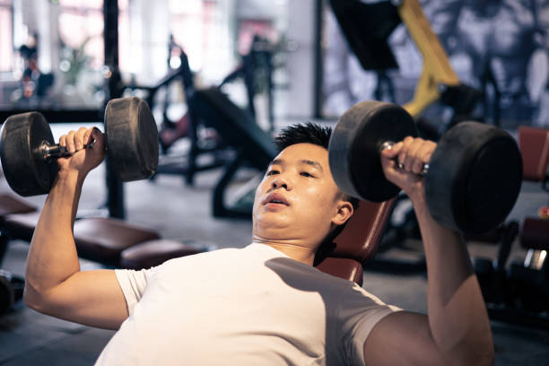 Man lifting dumbbells in the gym stock photo