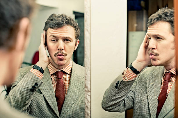 Man looking at reflection in mirror  vanity stock pictures, royalty-free photos & images