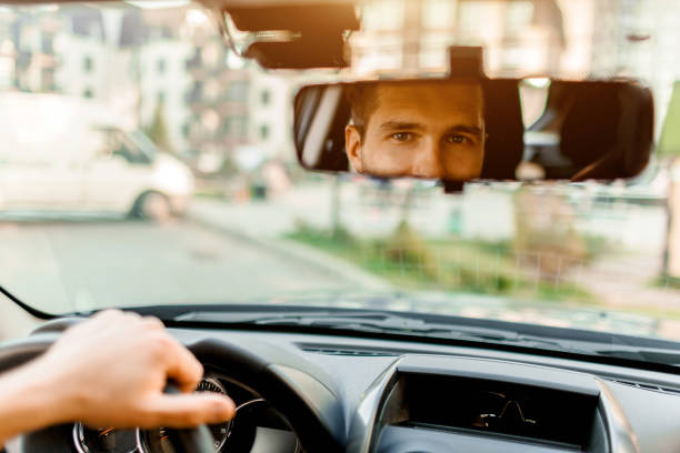 A man looks out the rear view window. In his car. Transportation concept A man looks out the rear view window. In his car. Transportation concept. vlad model photos stock pictures, royalty-free photos & images