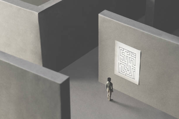 man lost in a complex maze, observing the map to find the way out;  surreal concept - lost first imagens e fotografias de stock