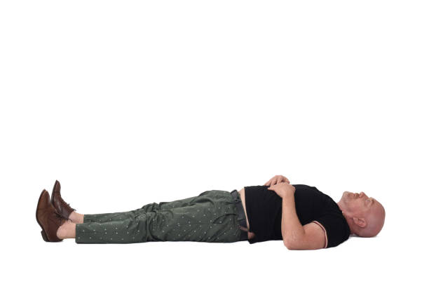 man lying on a floor on white background stock photo