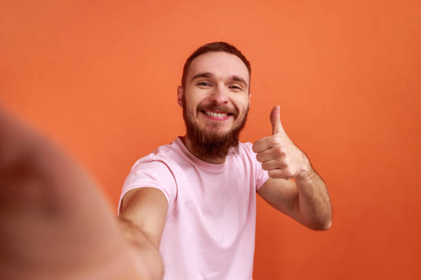 Man making selfie or streaming, showing thumb up POV, point of view of photo. stock photo