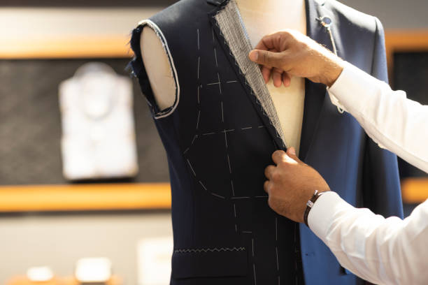 Man Measuring Jacket on Male Dress Form Man Measuring Jacket on Male Dress Form tailor stock pictures, royalty-free photos & images