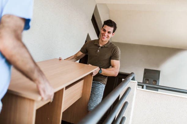 Man Movers Carrying Table On Staircase Of House stock photo