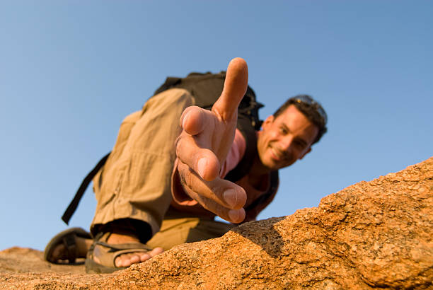 Man offering a hand up stock photo