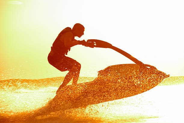 a man on a jet ski speeding through the waters - vattenskoter motor bildbanksfoton och bilder