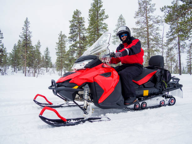 A Man on snowmobile in winter mountain stock photo