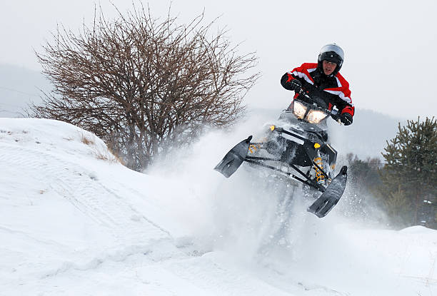Man on snowmobile jumping stock photo