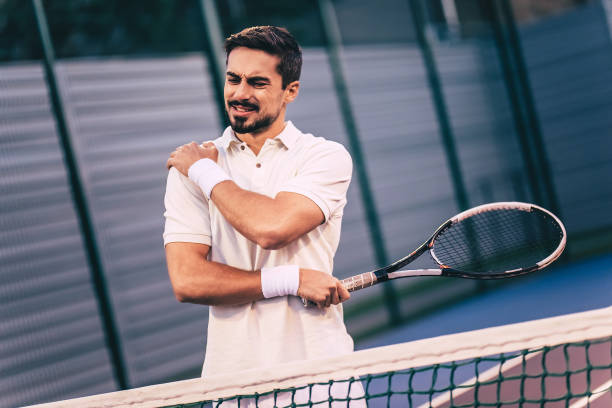 Man on tennis court. Handsome man on tennis court. Young tennis player. Shoulder pain human joint stock pictures, royalty-free photos & images