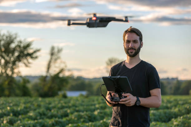 Man Pilot Using Drone Remote Controller at Sunset stock photo