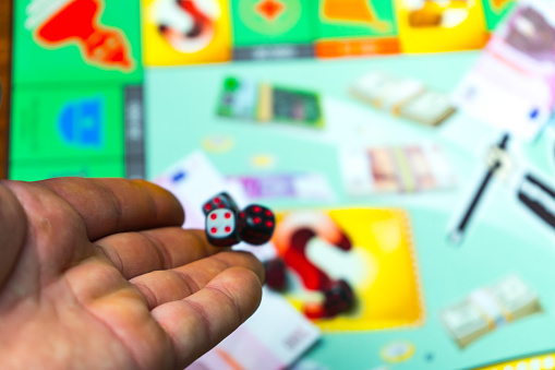 Man playing a Board game. The dice at the time of the roll