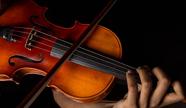 Man playing violin holding the bow stock photo