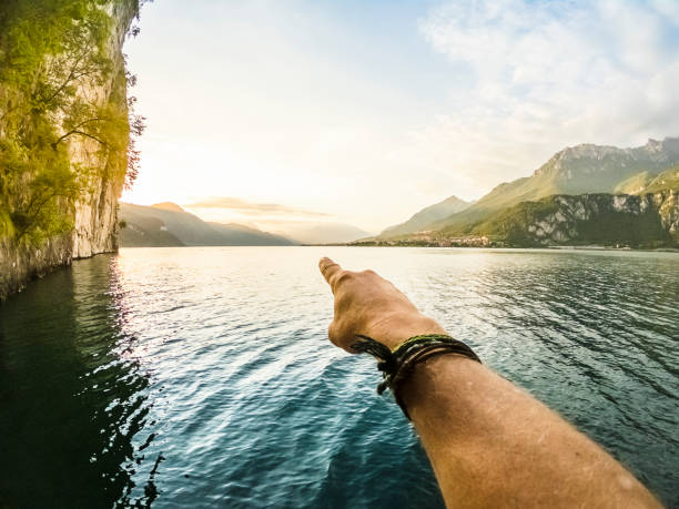 Man pointing lake panorama with hand, point of view wide angle stock photo