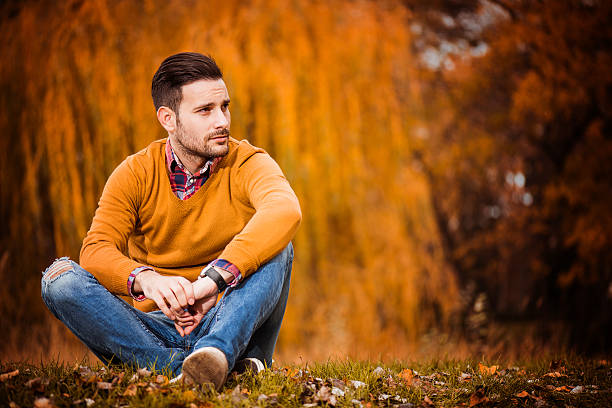 Man posing in autumn park stock photo