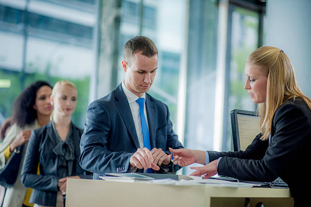 Man preparing to sign a bank contract Businessman applying for a loan at a bank teller. bank financial building stock pictures, royalty-free photos & images