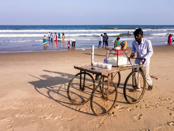 un uomo che spinge un carrello del cibo sulla spiaggia - kessie foto e immagini stock