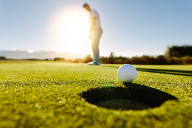 Photo of Man puts the ball on golf course green