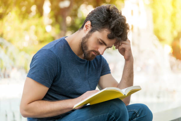 Man reading book stock photo