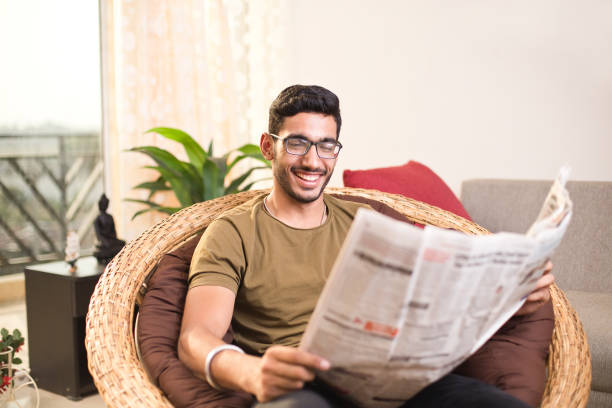 uomo che legge il giornale - young man read newspaper foto e immagini stock