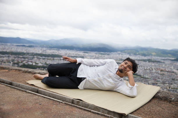 Man relaxing on mountain peak stock photo