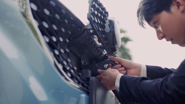 Man removing charging point from car stock photo