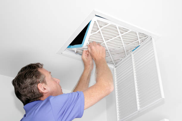 Man Removing Dirty Air Filter Mature man taking out a dirty air filter from a home ceiling air return vent. Male removing a dirty air filter with both hands in a house from a HVAC ceiling air vent. filtration stock pictures, royalty-free photos & images