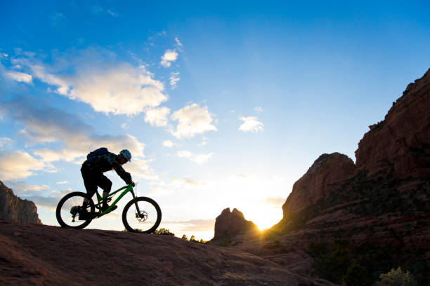 A man rides his enduro-style mountain bike at sunset in Sedona, Arizona, USA. stock photo