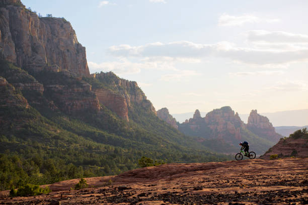 A man rides his enduro-style mountain bike at the end of the day in Sedona, Arizona, USA. stock photo