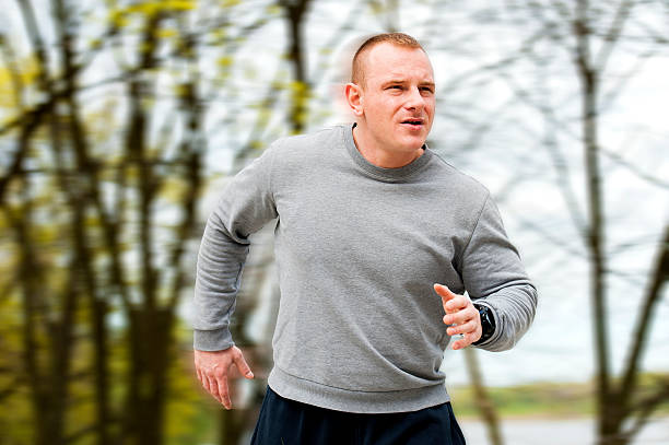 Man run by the river. Outdoor jogger. Blured background. stock photo