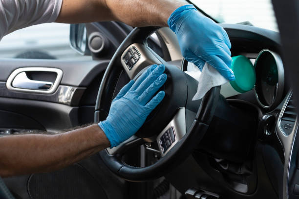 A man sanitizes his vehicle stock photo