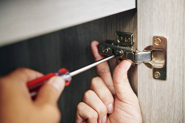 Man screwing door hinge Close-up image of handyman assembling kitchen cabinet and screwing door hinge cabinet stock pictures, royalty-free photos & images