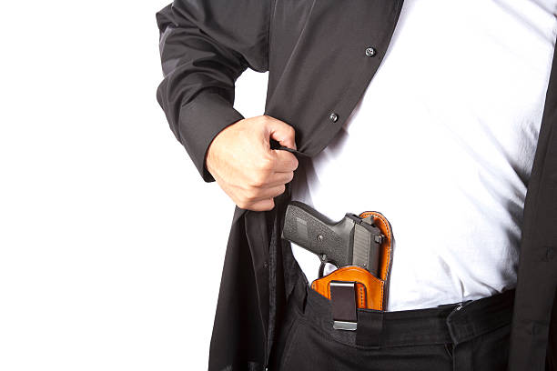 A man showing his concealed gun Example of concealed carry. Shot against a white background. carrying stock pictures, royalty-free photos & images