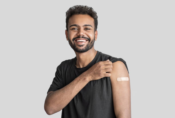 Man showing his vaccinated arm with plaster, got COVID-19 vaccine stock photo