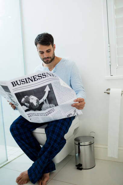Man sitting on a toilet seat, Stock Photo, Picture And 