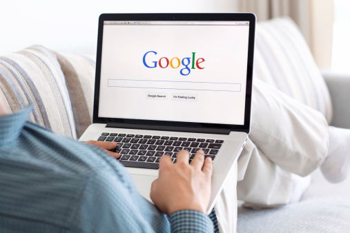 man sitting the MacBook retina with site Google on screen